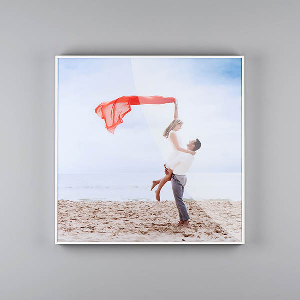 Custom photo wall art of a white perspex box frame of a couple on the beach with a red scarf